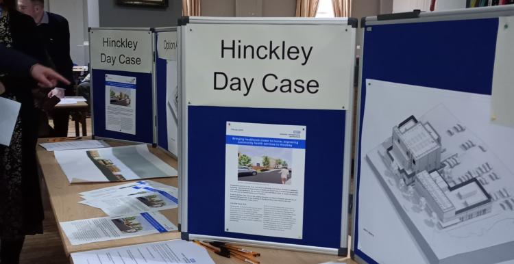 A table showing papers and a display stand for Hinckley Day Case Unit